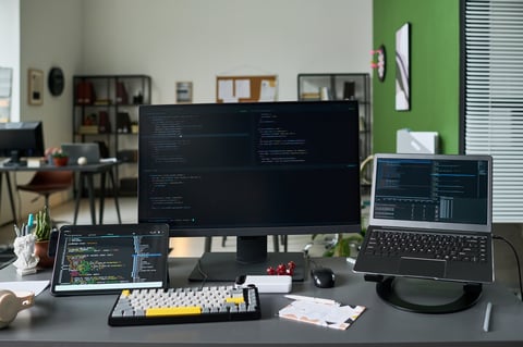 Professional workspace with multiple monitors showing code and design work